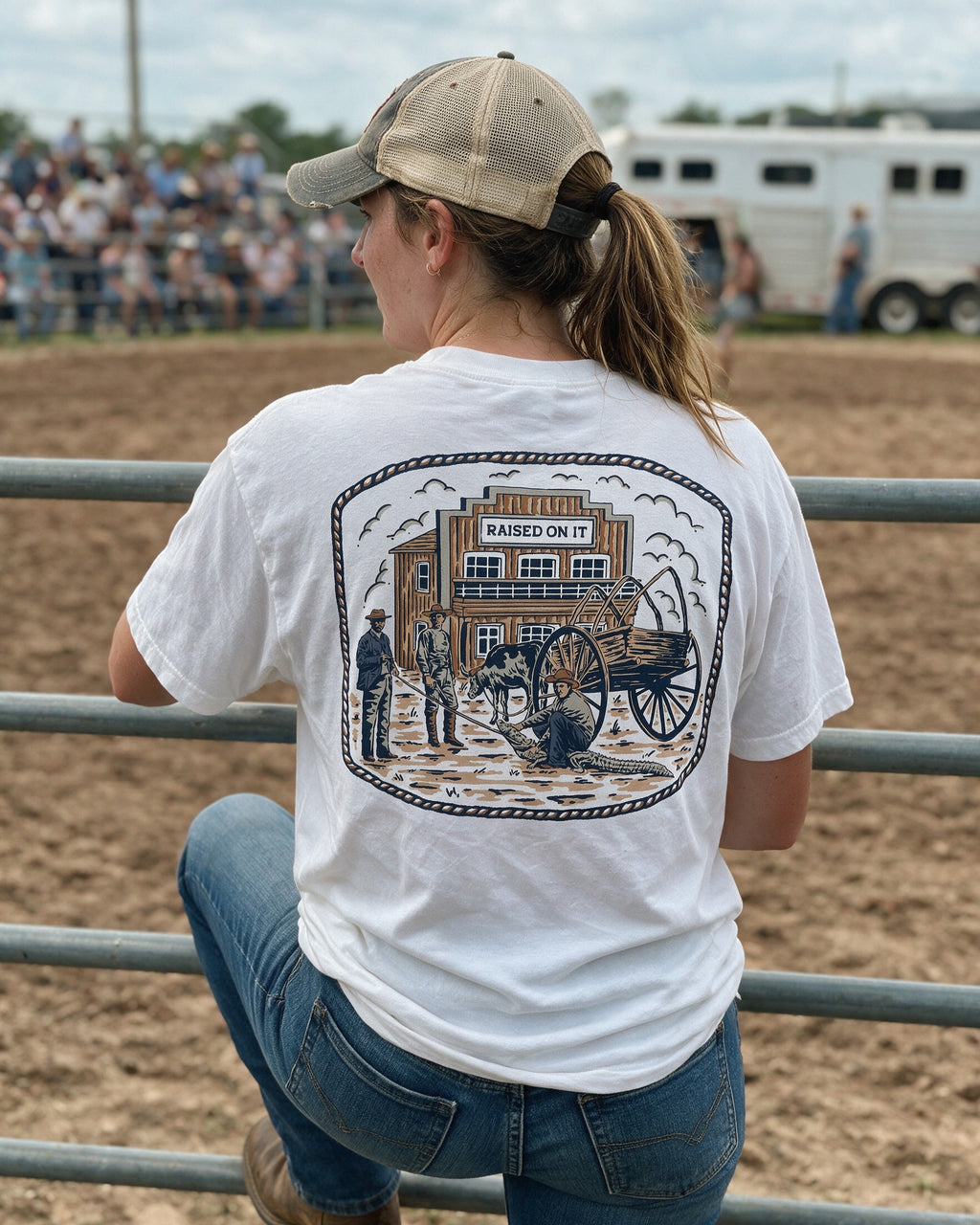 Woman at a rodeo arena rail wearing the Florida Cowboy tee, back print in view