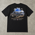 Raised On It All American Summer black tee back design, flat-lay on concrete